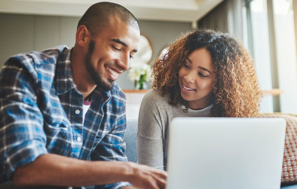 Young couple seated together looking at a laptop