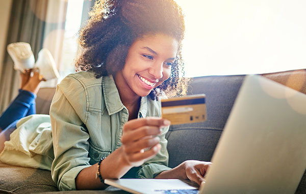 Young woman holding a credit card and using a laptop