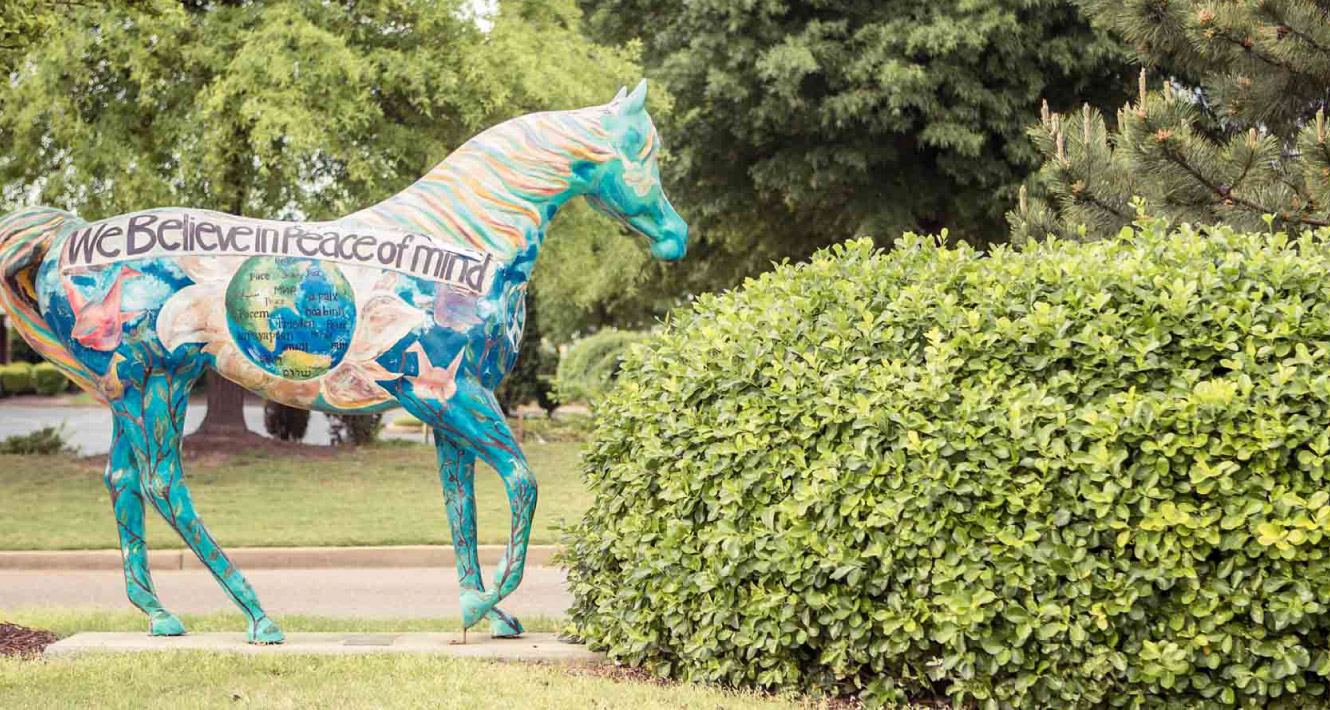 Horse sculpture with the words "We Believe in Peace of mind" written on the side.