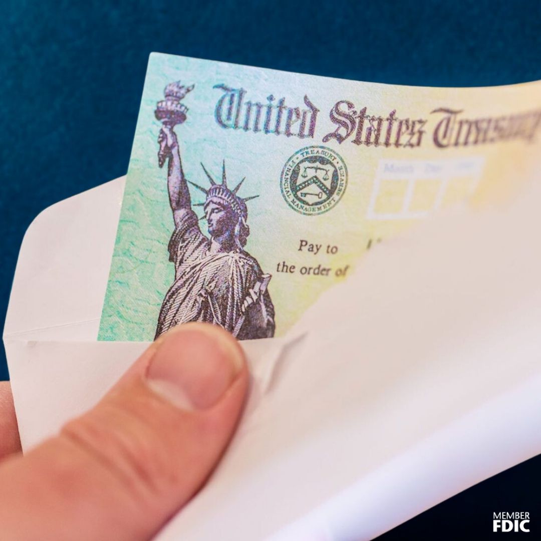 A white male holding a United States Treasury Check in an envelope.