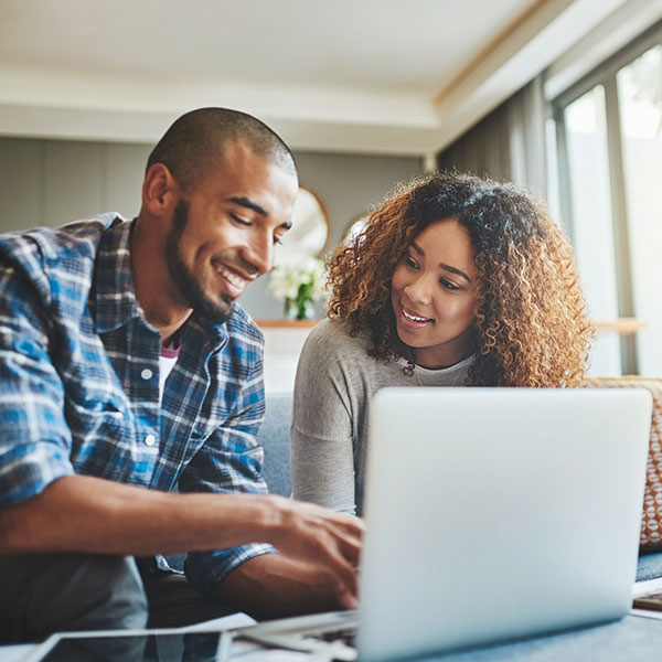 Young couple seated together looking at a laptop