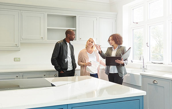 Couple with realtor inside an empty house