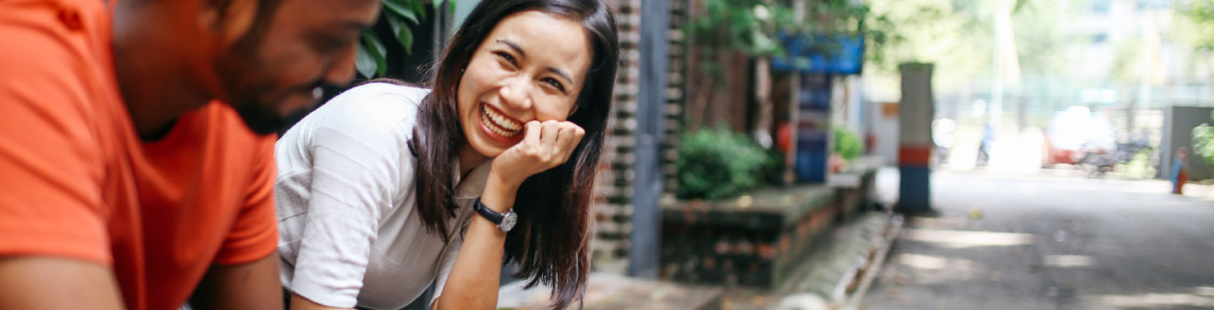 A young woman smiling at a person slightly off screen.