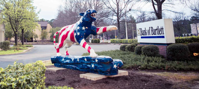Tiger sculpture painted red, white, and blue, outside of a Bank of Bartlett location.
