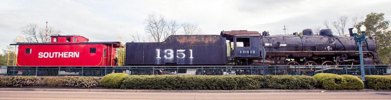 Wide shot of an old train engine and multiple carts behind it