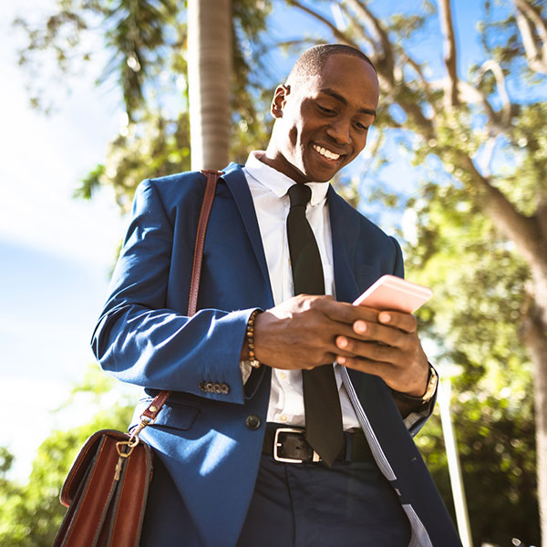 Young businessman looking down at his phone.