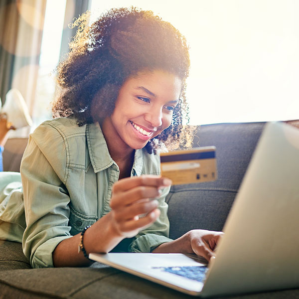 Young woman holding a credit card and using a laptop