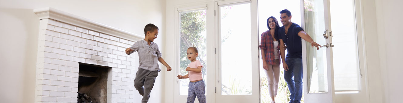 Wide shot of happy family entering new home.