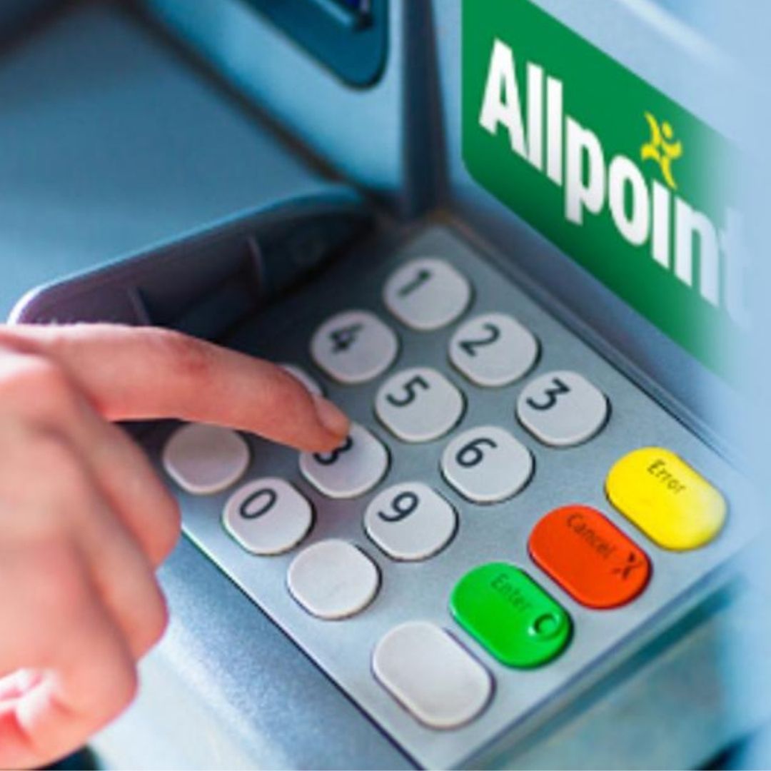 A picture of a person's hand touching numbers at an Allpoint ATM. 